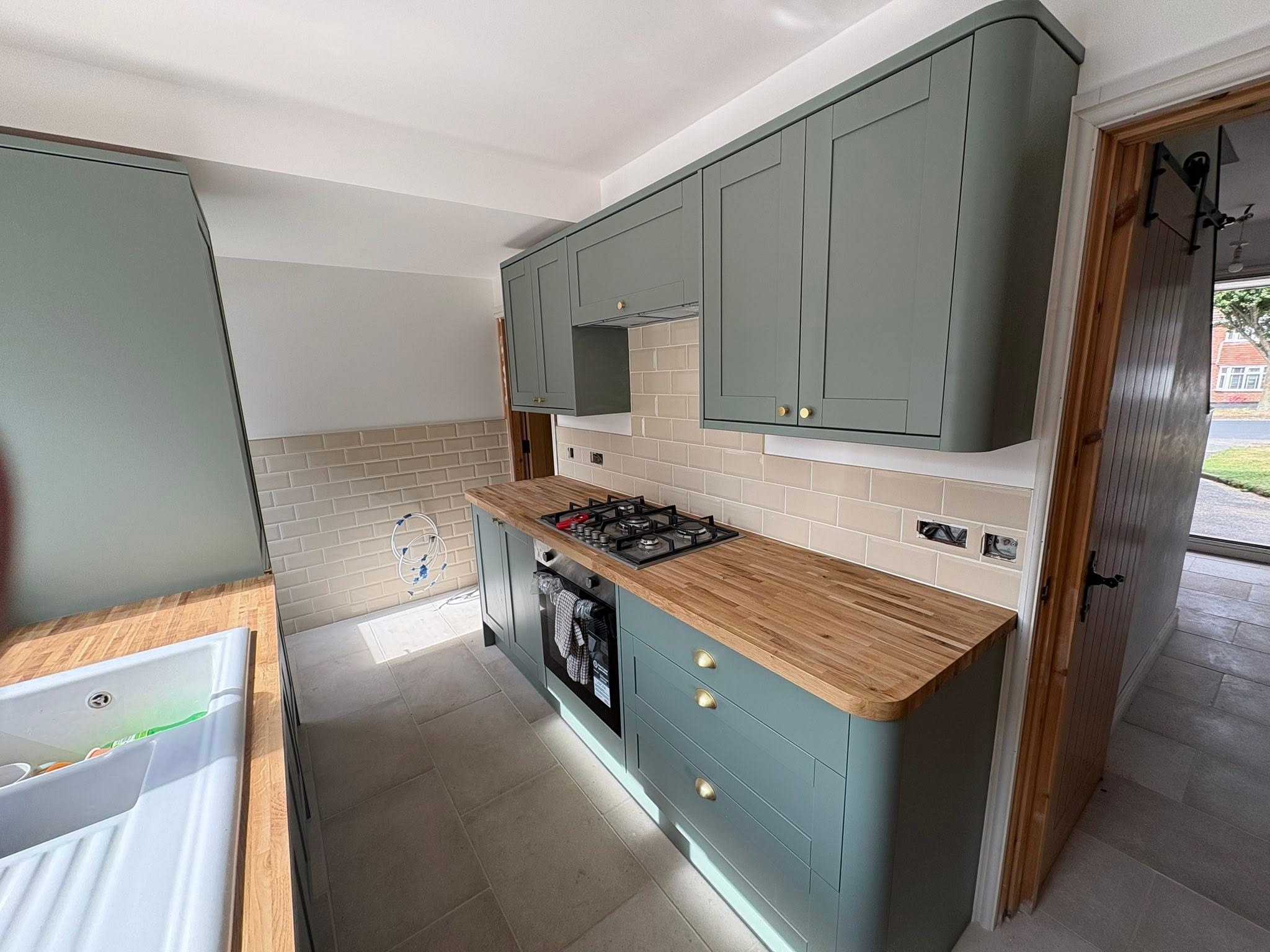 Green shaker kitchen with oak worktop and butler sink