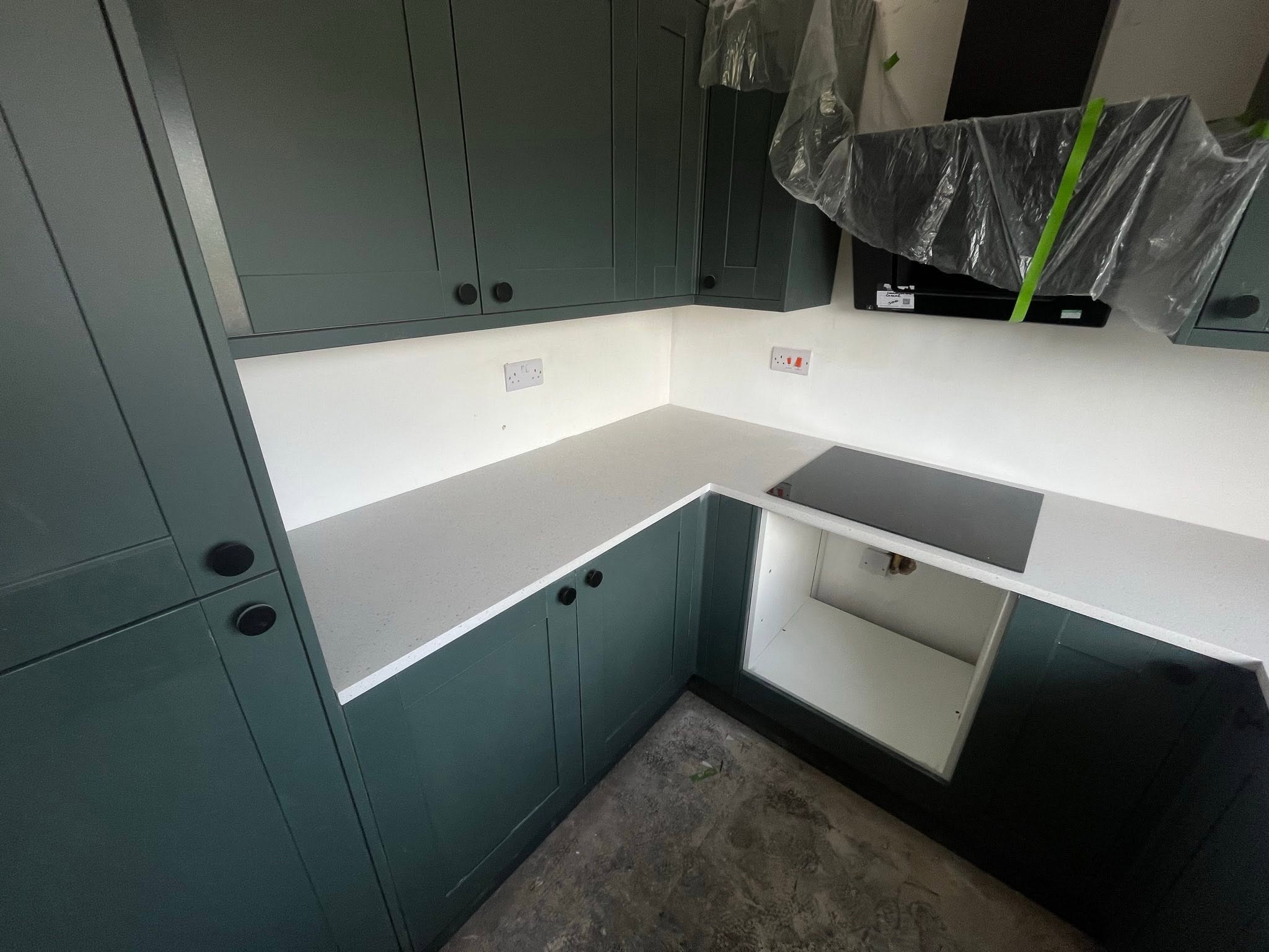 Dark green kitchen with white quartz worktop